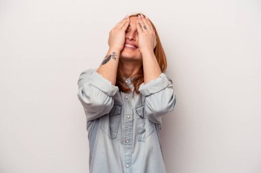 Beyaz arka planda soyutlanmış beyaz bir kadın ellerini başının üstünde tutarak neşeyle gülüyor. Mutluluk kavramı.