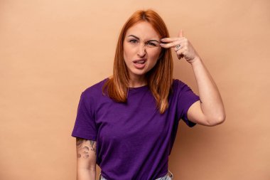 Beyazların arka planında izole edilmiş genç beyaz kadın işaret parmağıyla hayal kırıklığı jesti gösteriyor..