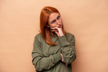 Beyazlı genç bir kadın bej arka planda izole edilmiş. Tekrarlanan bir görevden yorulmuş..