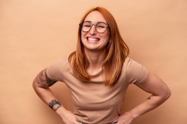 Genç beyaz kadın bej arka planda izole edilmiş mutlu, güler yüzlü ve neşeli..