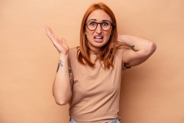 Beyazlı genç bir kadın bej arka planda izole edilmiş öfkeyle bağırıyor..