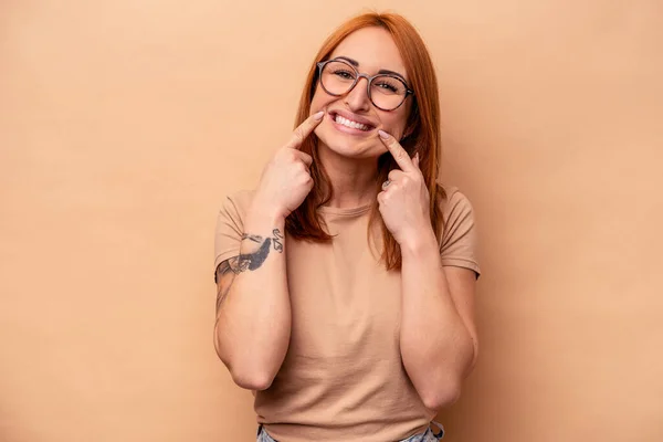 Mladá Běloška Izolovaná Béžovém Pozadí Usmívá Ukazuje Prsty Ústa — Stock fotografie
