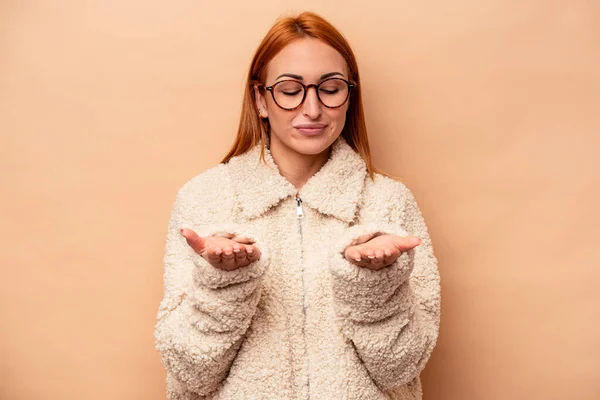 Joven Mujer Caucásica Aislada Sobre Fondo Beige Sosteniendo Algo Con —  Fotos de Stock