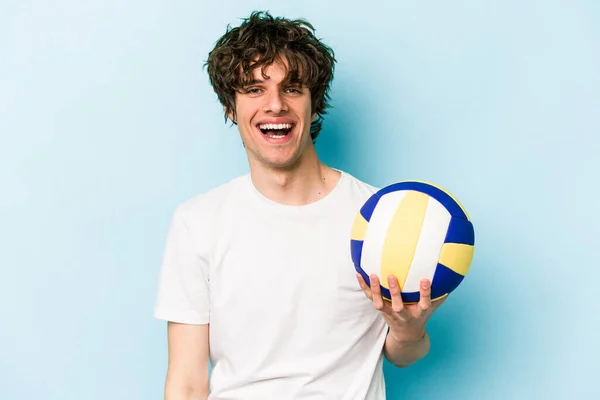 若いですCaucasian男プレイバレーボール隔離上の青の背景幸せな 笑顔と陽気な — ストック写真