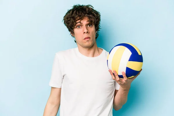 Young Caucasian Man Playing Volleyball Isolated Blue Background Shrugs Shoulders — Stock Photo, Image