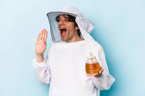 Young Caucasian Beekeeper Man Isolated Blue Background Shouting Holding Palm — Stock Photo, Image