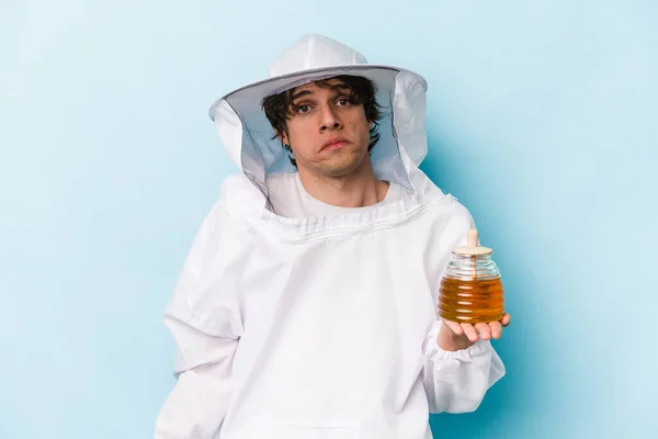 Young Caucasian Beekeeper Man Isolated Blue Background Shrugs Shoulders Open — Stock Photo, Image