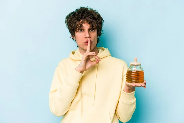 Young Caucasian Man Holding Honey Isolated Blue Background Keeping Secret — Stock Photo, Image