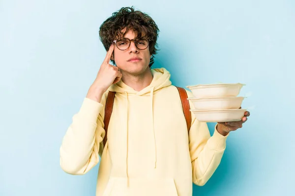 Jovem Estudante Caucasiano Segurando Tupperware Isolado Fundo Azul Apontando Templo — Fotografia de Stock