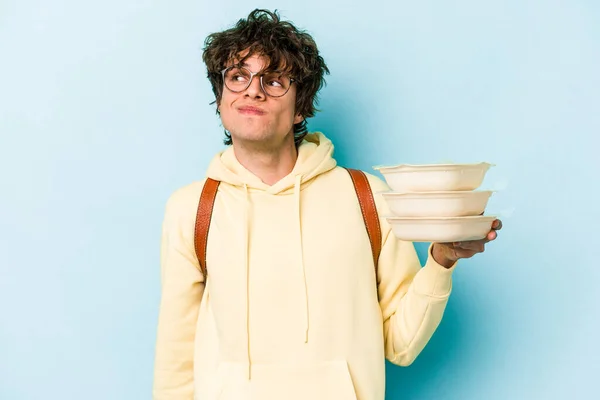 Jeune Étudiant Caucasien Tenant Tupperware Isolé Sur Fond Bleu Rêvant — Photo