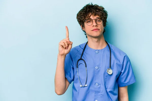 Jonge Kaukasische Verpleegkundige Man Geïsoleerd Blauwe Achtergrond Tonen Nummer Een — Stockfoto