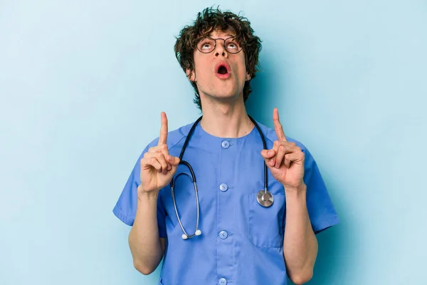 Jonge Kaukasische Verpleegkundige Man Geïsoleerd Blauwe Achtergrond Wijzend Ondersteboven Met — Stockfoto