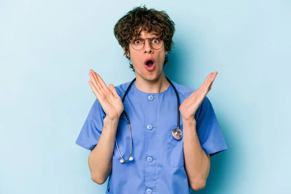 Ung Kaukasiska Sjuksköterska Man Isolerad Blå Bakgrund Förvånad Och Chockad — Stockfoto