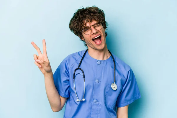 Jonge Kaukasische Verpleegkundige Man Geïsoleerd Blauwe Achtergrond Vreugdevol Zorgeloos Tonen — Stockfoto