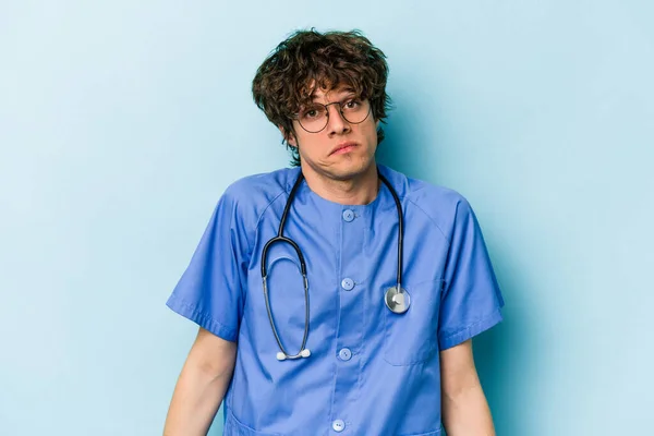Jonge Kaukasische Verpleegkundige Man Geïsoleerd Blauwe Achtergrond Shrugs Schouders Open — Stockfoto
