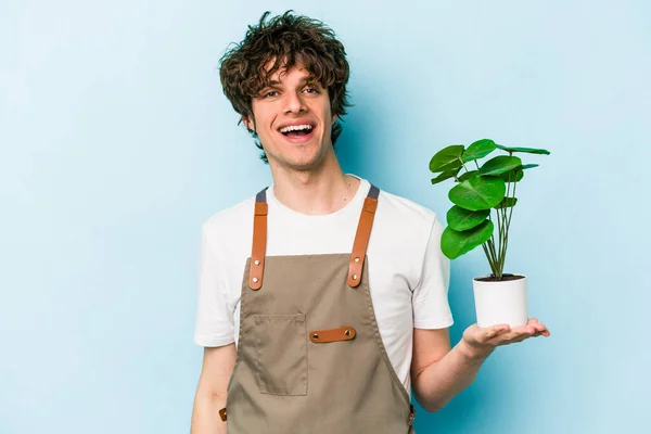 Genç Bahçıvan Beyaz Bir Adam Mavi Arka Planda Bir Bitki — Stok fotoğraf