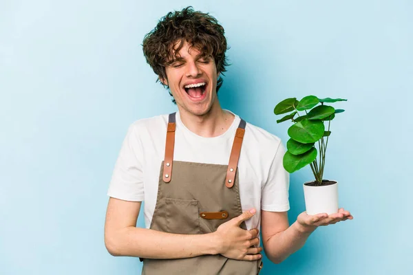 Jovem Jardineiro Caucasiano Homem Segurando Uma Planta Isolada Fundo Azul — Fotografia de Stock