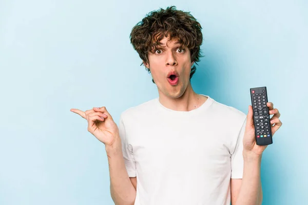 Young Caucasian Man Holding Controller Isolated Blue Background Pointing Side — 스톡 사진