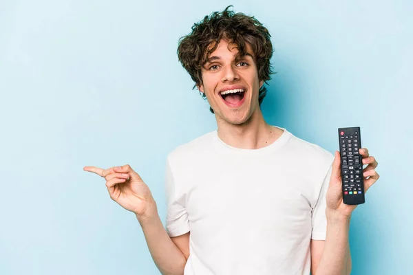 Young Caucasian Man Holding Controller Isolated Blue Background Smiling Pointing — 스톡 사진