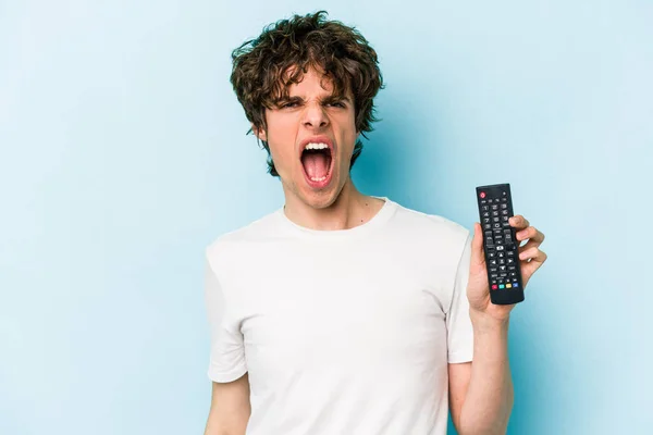 Young Caucasian Man Holding Controller Isolated Blue Background Screaming Very — 스톡 사진