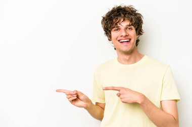 Beyaz arka planda izole edilmiş genç beyaz bir adam işaret parmağıyla işaret ettiği için heyecanlı..