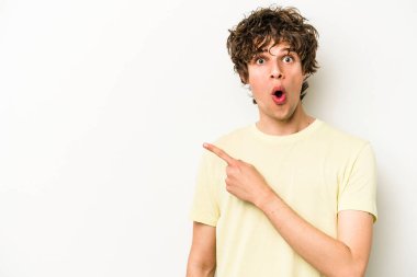 Beyaz arka planda izole edilmiş genç beyaz adam yan tarafı işaret ediyor