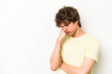 Beyaz arka planda izole edilmiş, üzgün ve dalgın hisseden genç beyaz bir adam fotokopi alanına bakıyor..