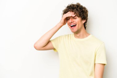 Beyaz arka planda izole olmuş genç beyaz bir adam gülüyor, kaygısız, doğal bir duygu..