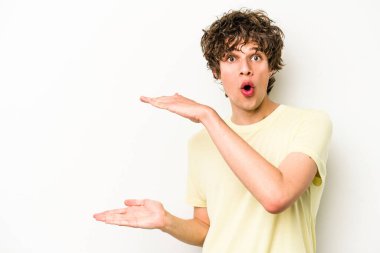 Beyaz arka planda izole edilmiş genç beyaz adam elleri arasında bir kopya alanı tutarken şok ve hayrete düştü..