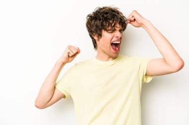 Beyaz arka planda izole edilmiş genç beyaz bir adam zaferden sonra yumruğunu kaldırıyor, kazanan konsept.