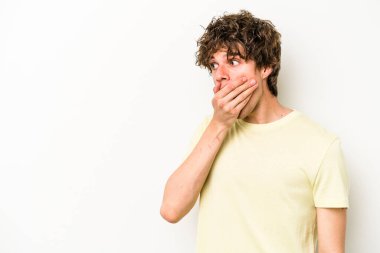 Beyaz arka planda izole edilmiş beyaz tenli genç adam ağzını eliyle kapatan bir fotokopi odasına bakıyor..