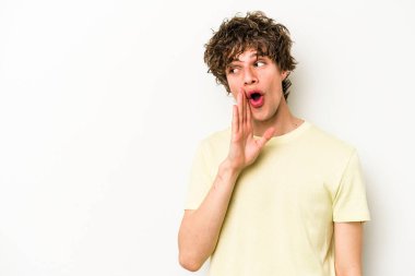 Beyaz arka planda izole edilmiş genç beyaz bir adam gizli bir sıcak fren haberi veriyor ve yana bakıyor.