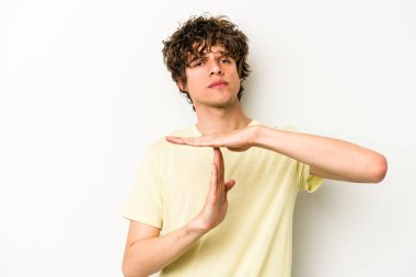 Beyaz arka planda izole edilmiş genç beyaz bir adam bir mola hareketi gösteriyor..