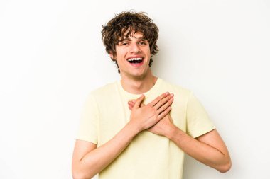 Beyaz arka planda izole edilmiş beyaz tenli genç bir adam, dostane bir ifadeye sahip, avuçlarını göğsüne bastırıyor. Aşk konsepti.