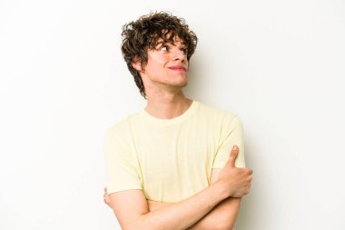 Beyaz arka planda izole edilmiş genç beyaz adam hedeflere ve amaçlara ulaşmayı hayal ediyor.