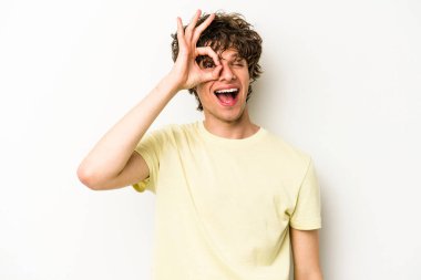 Beyaz arka planda izole genç beyaz adam heyecanlı tamam göz jesti tutmak.