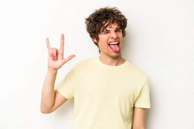 Beyaz arka planda izole edilmiş genç beyaz bir adam boynuzlarını devrim konsepti olarak gösteriyor..