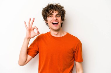 Beyaz arka planda izole edilmiş genç beyaz bir adam neşeli ve kendinden emin..