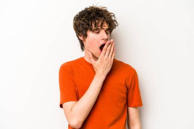 Beyaz arka planda izole edilmiş genç beyaz adam esniyor. Ağzı eliyle kapatan yorgun bir hareket sergiliyor..