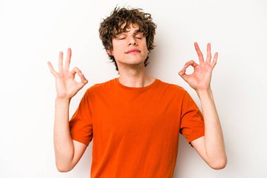 Beyaz arka planda izole edilmiş genç beyaz adam yoğun bir günün ardından rahatlıyor. Yoga yapıyor..