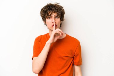 Beyaz arka planda izole edilmiş genç beyaz bir adam ya sır saklıyor ya da sessizlik istiyor..