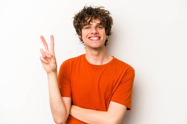 Beyaz arka planda izole edilmiş genç beyaz adam iki numarayı parmaklarıyla gösteriyor..