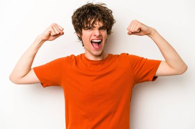 Beyaz arka planda izole edilmiş genç beyaz bir adam güçlü bir hareket gösteriyor, kollarıyla, kadınsı gücün sembolü.