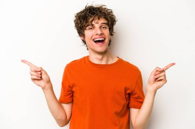 Beyaz arka planda izole edilmiş genç beyaz bir adam farklı kopya alanlarını gösteriyor, birini seçiyor, parmaklarıyla gösteriyor..