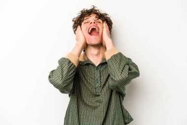 Beyaz arka planda izole olmuş genç beyaz bir adam ellerini başının üstünde tutarak neşeyle gülüyor. Mutluluk kavramı.