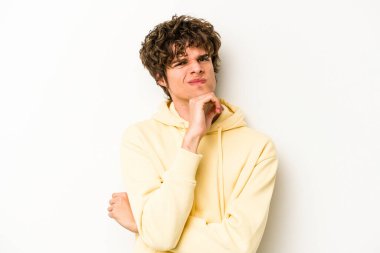 Beyaz arka planda soyutlanmış genç beyaz bir adam düşünüyor ve yukarı bakıyor, yansıtıyor, düşünüyor, hayal kuruyor..