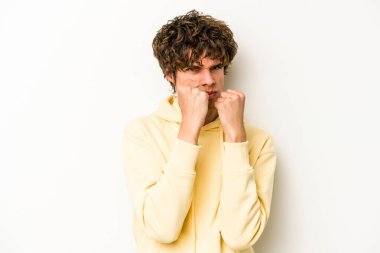 Beyaz arka planda izole olmuş genç beyaz bir adam bir tartışma yüzünden yumruk atıyor, sinirleniyor, kavga ediyor, boks yapıyor..