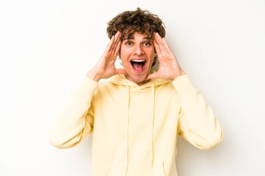 Beyaz arka planda izole genç beyaz adam hoş bir sürpriz alıyor, heyecanlı ve el kaldırıyor..