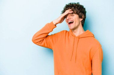 Kafkasyalı genç adam mavi arka planda yalnızdı gülerek, kaygısızca, doğal duygularla.