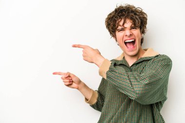Beyaz arka planda izole edilmiş genç beyaz bir adam işaret parmağıyla işaret ettiği için heyecanlı..